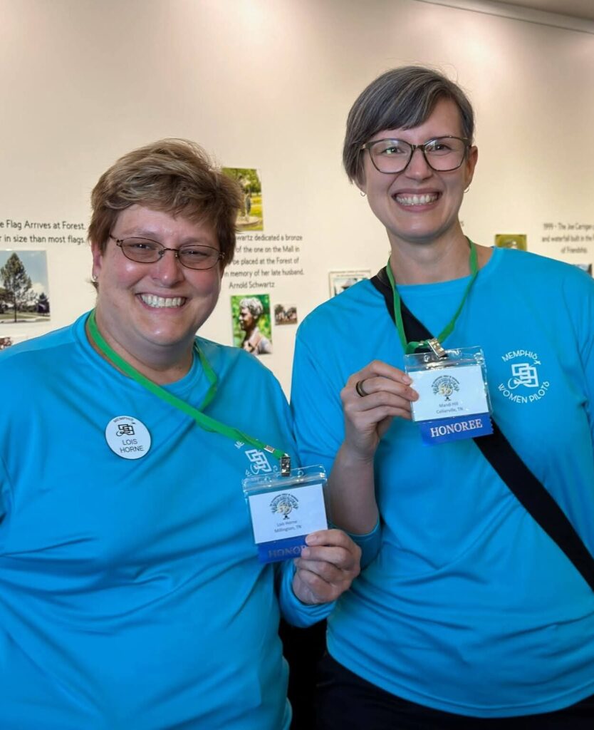 Mandi Hill and Lois Horne show of their name badges with "Honoree" ribbons.