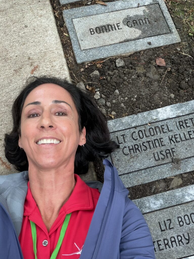 Christine Kelley lies beside her name plaque in the Forest of Friendship walkway.