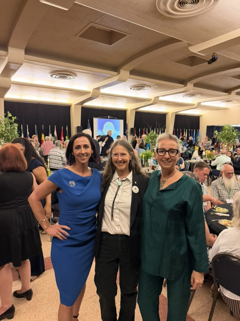 Lt. Colonel (Ret.) Christine Kelley (left) and Liz Booker (right) stand inside the conference room with fellow Ninety-Nines member and current International President Terri Donner (middle) before the ceremony. Their three plaques are side by side in the Forest.